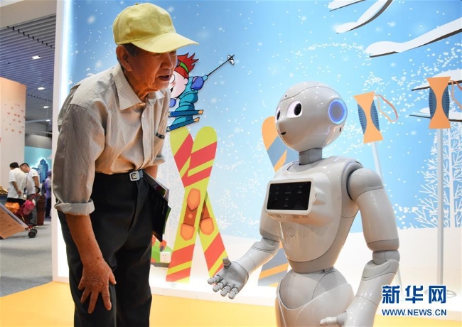 5月21日，在活动周主场，观众与云端智能机器人互动。 5月19日至26日是2019年全国科技活动周，今年的主题是“科技强国 科普惠民”。在北京的活动周主场，410个代表着我国科技创新最前沿成果的展项一一亮相。 新华社发（任超摄）