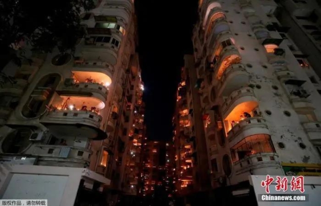 当地时间4月5日21点，印度民众熄灯9分钟，点燃蜡烛和油灯为抗疫祈福。图为印度艾哈迈达巴德民众站阳台上燃起烛光。